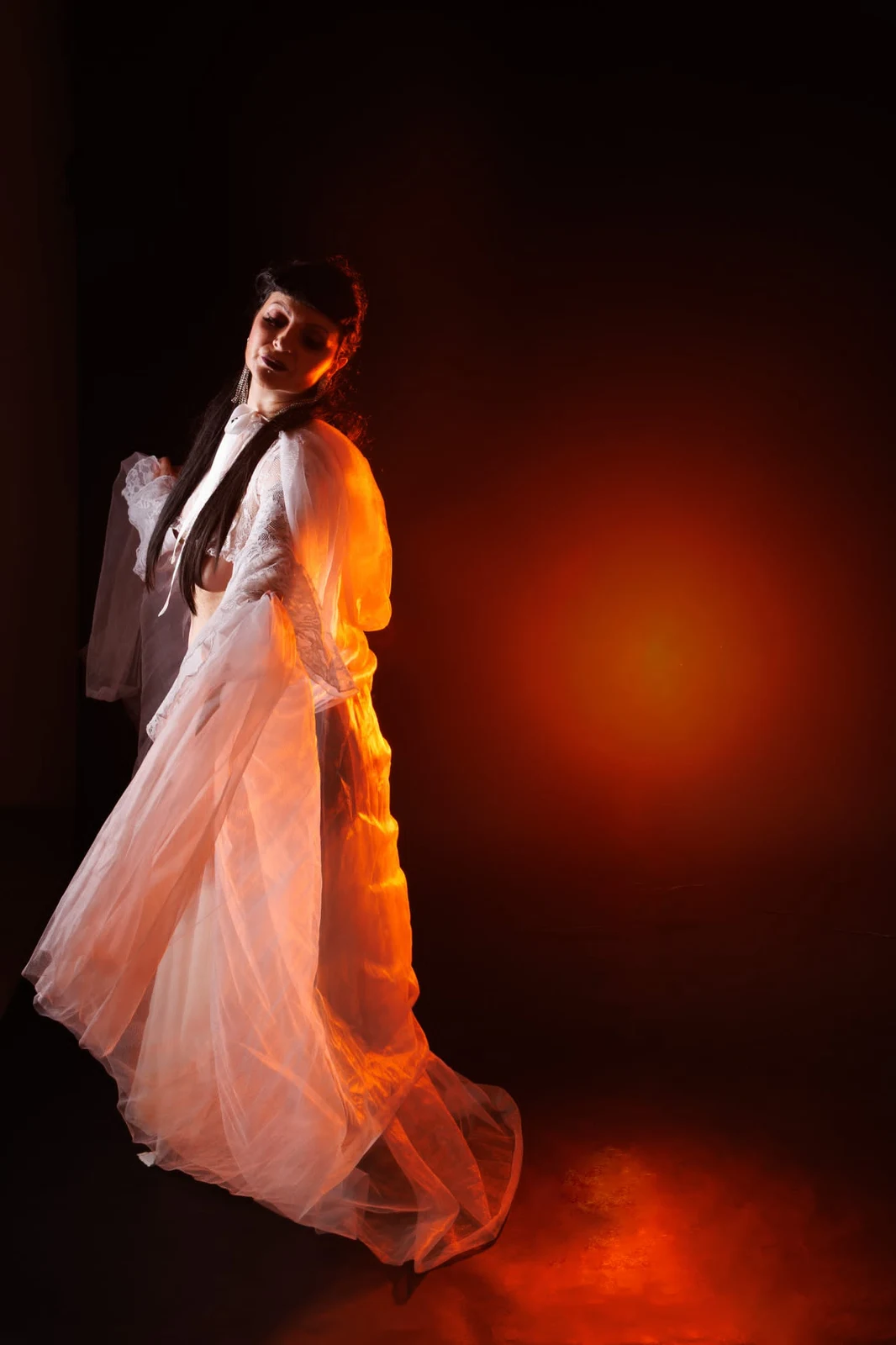 Anaïs Lune turning in a flowing white robe against warm orange light