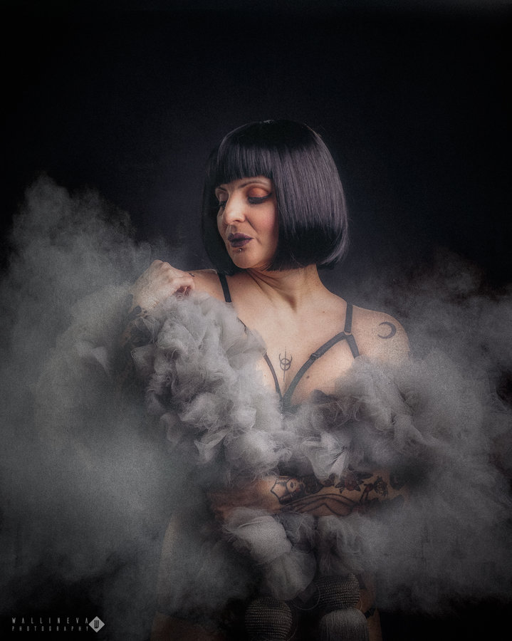 Anaïs Lune surrounded by dramatic white smoke, studio portrait