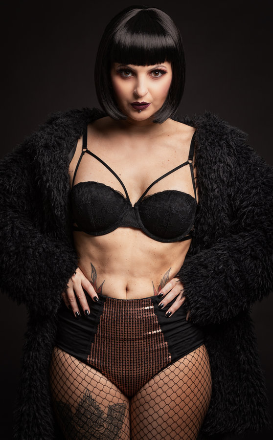 Anaïs Lune in black lingerie and open fur coat, studio portrait