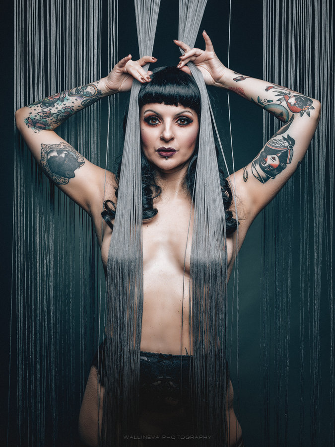 Anaïs Lune framed by silver tinsel strands